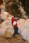 5-year-old Aidan Allison takes a different approach to searching
for the eggs - he flung the paper grass high and wide in search of
the eggs, which were filled with candy and marked for prize