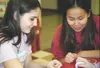 Sabrina Glowacki, 15, and Mandy Jessup, 16, entertain themselves
at a table in Wasilla High School's commons area Thursday night.
The teens' family took advantage of the Red Cross emergency s