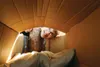Tommy Rainey peeks through a temporary hole in his homemade dwelling at Cardboard City 2014 Frontiersman file art