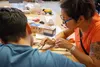 A behavioral health associate at Volunteers of America Alaska’s Adolescent Residential Center for Help teaches a youth to braid a bracelet during a culturally focused, partner-funded wellness