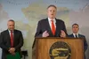 Gov. Mike Dunleavy speaks about new Trump administration policies at a news conference Wednesday in his Anchorage office. Behind him are Attorney General Treg Taylor and Department of Natural