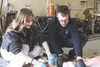 Lili Bailey, left, receives instruction from Alaska wildlife teacher Ryan Judd, right, as they work on a rear quarter of the moose. Kyle Wilkinson/For the Frontiersman