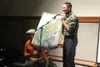 Emcee Mike Wood and storyteller, Joshua Ashline, hold up the gift for presenting a story: a map of the Matanuska Basin. JACOB MANN/Frontiersman