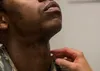 Staff Sgt. Antoine, 13th Intelligence Squadron intelligence analyst, raises his head as Lt. Col. David Gregory, 9th Medical Group flight surgeon chief of medical staff, inspects his neck and 
