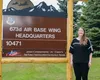 Kristi Adams, 673d Air Base Wing privatized housing resident advocate, poses in front of the 673d ABW Headquarters sign at Joint Base Elmendorf-Richardson, Alaska, June 25, 2021. The privatiz