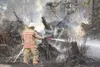 ROBERT DeBERRY/Frontiersman A member of the Mat-Su Central Fire
Department sprays an area of downed trees and grass off Foothill
Boulevard on Friday.