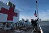 Sailors participate in a morning colors ceremony aboard the hospital ship USNS Comfort (T-AH 20) while the ship is moored in New York City in support of the nation’s COVID-19 response efforts