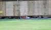 An Athletes in Action Fire coach lays on the cement outside of
Hermon Brothers Field and peeks through the gap between the ground
and the outfield fence after being ejected from a game Tuesda