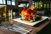 A cozy interior looking out over expansive views of Lake Lucille and Pioneer Peak await diners at Wasilla’s Chop House, which features a Burger and Brew special every Monday night starting at