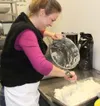 GREG JOHNSON/Frontiersman Frances Walker smiles while preparing
a mountain of mashed potatoes. She mashed ‘more than I can count,’
she said. ‘It never stops.’