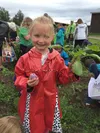 A participant in the 2016 Agriculture Appreciation Day at the Farm shows off a radish she harvested. Photo by Stephen Brown