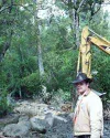 Robert Moore rented a backhoe to clear his driveway bridge and
control flooding on his property after McRoberts Creek overflowed
its banks Tuesday. Some of the stream was diverted upstream fr