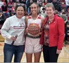 Wasilla senior Mylee Anderson, center, was recognized for scoring her 1,000th career point. Also pictured are Wasilla activities principal Stacia Rustad, left, and head coach Jeannie Hebert-T
