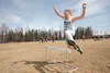 Meadow Lakes Elementary fourth-grader Audrey Hoglund clears a hurdle on the obstacle course during the district-wide track meet Saturday at Houston High School. ROBERT DeBERRY/Frontiersman.co