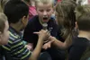 Second-grade student Teagan Hendrickson expresses his surprise that the 'ice' in the beaker is hot, not cold, after perceiving the pre-frozen water as cold seconds earlier. The conundrum was 