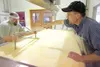 ROBERT DeBERRY/Frontiersman file photo Matt Lewis, left, and
Kyle Beus run a cheese cutter through a large vat processing cheese
at the creamery’s Palmer-Wasilla Highway location. It takes fi
