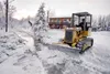 Jay Thornsley uses a small bulldozer to clear ice and getting water flowing through a channel to help reduce flooding near mile 13 of the Old Glenn Highway Thursday afternoon. State officials