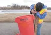 City of Wasilla Parks and Recreation Department employee Larissa McMahill attaches a trash can to a post at Harold J. Newcomb Park in anticipation of the summer season and Wasilla Clean Up Da