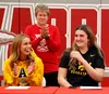 Wasilla senior Mylee Anderson, Warriors girls basketball head coach Jeannie Hebert-Truax and senior Layla Hays celebrate the opportunity for Anderson and Hays to play college basketball durin