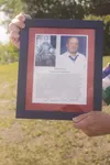 A framed photo of Bud Hawk sits over text describing the conduct that led to his receipt of the Medal of Honor for his conduct in World War II. Hawk’s friend and one-time student Raymond Lee 