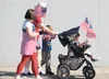Melody McCullough and her three grandchildren walk with flags in hand in front of the Wasilla Post Office before the start of the 2013 Memorial Day procession to the Aurora Cemetery. Frontier