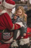 Kinsel Ahern, 6, of Wasilla, happily receives a candy cane from Santa at Denali Harley Davidson Saturday. Kinsel came to the dealership with her grandmother Rita Martinez. J. David McChesney/