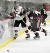 Kenai Central's Matthew Zorbas and Houston's Ree Humphreys tangle along the boards Friday at the Soldotna Regional Sports Complex during the Peninsula Ice Challenge. Photo by Jeff Helminiak/P