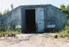 The doors to one of the weapons storage bunkers have been
blasted and pulled open, evidence of the determination of looters
and vandals trespassing illegally at the site. Inset, portions of
t