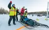 Emily Krol, with the help of a teammate and safety jacket clad-race officials, launches her team off the starting line on Knik Lake in 2024. J. David McChesney/Frontiersman