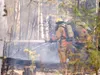 Firefighters from the West Lakes Fire Department spray water on a house behind Lakesway Greenhouse in Big Lake Monday afternoon. ROBERT DeBERRY/Frontiersman.com