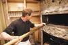 Gordon Fletcher stirs the coals inside the wood-fired pizza oven at Humdinger’s Gourmet Pizza Co. in Palmer. Fletcher opened in August and has been packing the house with his unique gourmet p