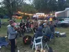 A group of musicians and festival goers sing around a campfire at the Pickers Retreat. Courtesy art