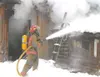 TODD L. DISHER/Frontiersman Firefighters used foam to put out
the fire off of Fairview Loop. The inside of the original log cabin
with multiple additions was completely destroyed.