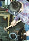 Jeremiah Kaster shapes a shoe on the anvil. Inset, a tray of
tools sits beside a farrier's anvil. Many hammers were flying at
H&amp;C Feed in Palmer last weekend, as farriers got together to
