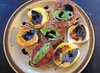 A mix of purple and green basil and a balsamic reduction atop pieces of caprese and different colored tomatoes makes a more colorful plate.  Courtesy of Jamie Drysdale/Blue Coyote Farm