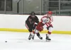 Wasilla defenseman Austin Stephens passes the puck across the zone as Kenai Centra's Zach Burnett tries to reach with his stick during Wasilla's 13-2 win over the Kardinals Friday in Wasilla.