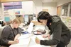 ROBERT DeBERRY/Frontiersman Amy Seamans, left, of the Mat-Su
Student Services Department assists incoming freshman Arianna Sitka
Bertolini with registration for fall semester Mat-Su College.
