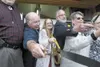 Nugen's Ranch Executive Director Karen Nugen-Logan, center, uses
big scissors to cut the ribbon during the grand opening ceremony
Saturday for the new Nugen's Ranch location at Point MacKenzi