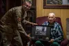 Retired U.S. Air Force Staff Sergeant Dennis Provencher, airborne and ground radio operator, right, talks with a group of Airmen including Lt. Col. Denial Waid, 18th Communications Squadron c