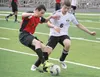 Houston's Aaron Drake battles Nikiski's Nathan Carstens for the ball during the Bulldogs' 3-0 win over the Hawks April 18 at Houston High School. Jeremiah Bartz