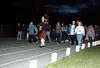 Accompanied by a bagpiper, people make their way around the
Colony High School track at midnight Friday during the luminary
ceremony during the Relay for Life event. Names of cancer victims
a