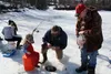 James Neslund, center, and his son Bjorn, left, fish through the ice at Seventeen Mile Lake. Jonathan Rockey, right, the pastor at St. John Lutheran Church, organizes the event in the honor o