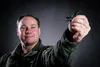 U.S. Air Force Staff Sgt. Justin Novak, an airborne radio operator assigned to the 962d Airborne Air Control Squadron, poses with a miniature model of an F-15 Eagle at Joint Base Elmendorf-Ri