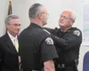 George R. Boatright, right, retires as chief of the Palmer Police Department Friday after more than a decade, and pins the rank’s insignia to the collar of his replacement, Tom Remaley, cente