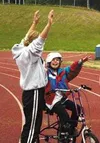 Mindy Baldwin celebrates riding a bike for the first time, along
with her counselor, Becca Smith. For many of the participants of
Camp Abilities, it was the first time they had ever even touc