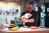 Piece of Cake co-owner Neve Michael frosts a layer of cake in her mother's (and business partner's) kitchen, which currently serves as the pick up location and creation center of all their co