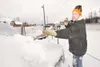 ROBERT DeBERRY/Frontiersman Park and sell owner Jason Lindfors
brushes snow off one of 75 vehicles at his lot along the
Palmer-Wasilla Thursday morning. Lindfors says it takes him about
four 