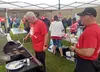 Robb Donohue Boyer and Justin Lacoss serve burgers and hot dogs outside the Mat-Su Borough School District office. Jacob Mann/Frontiersman