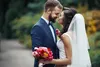 Handsome groom hugging beautiful bride with bouquet in romantic european park IVASHstudio - stock.adobe.com