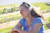 Jan Newman sits in the morning sun in the edible park she helped create behind the Salvation Army in Palmer. HEATHER A. RESZ/Frontiersman